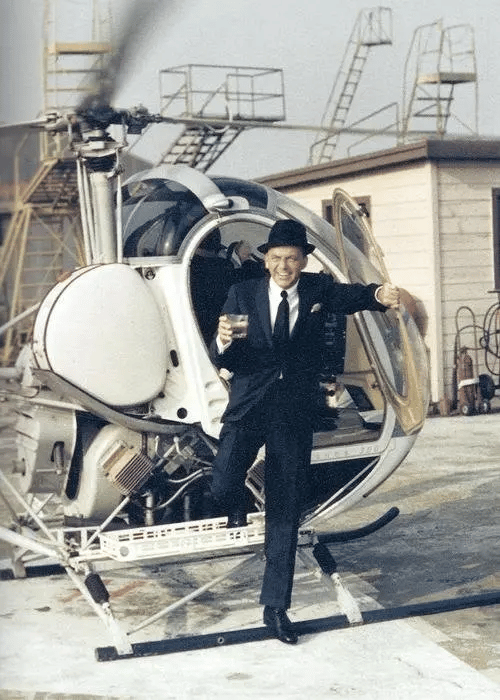 Frank Sinatra bajando de un helicóptero con una bebida en la mano, Yul Brynner, (1964).