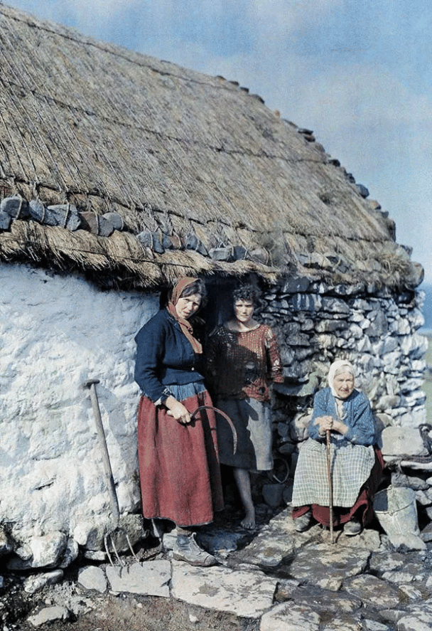 Tres generaciones de mujeres frente a su casa de piedra en Irlanda. (1927).