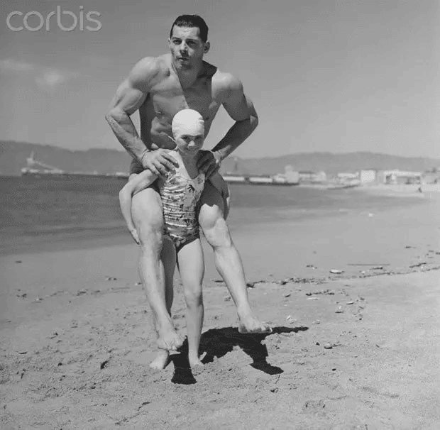 En una notable demostración de fuerza, Patricia O'Keefe, que pesa solo 29 kilogramos, sostiene 90 kilogramos de Wayne Long en su espalda (29 de marzo de 1940).