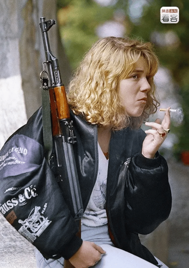 Una niña bosnia sostiene un rifle AK-47 y fuma un cigarrillo mientras espera su funeral en el cementerio de Lion en Sarajevo (14 de septiembre de 1992).