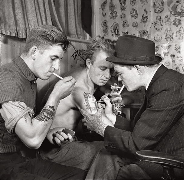 Hombres en un salón de tatuajes. (1940 o 50).