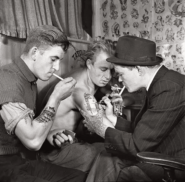 Hombres en un salón de tatuajes. (1940 o 50).