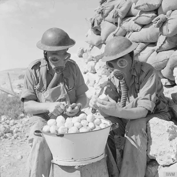 Soldados con máscaras antigás pelando cebollas cerca de Tobruk, 15 de octubre de 1941.