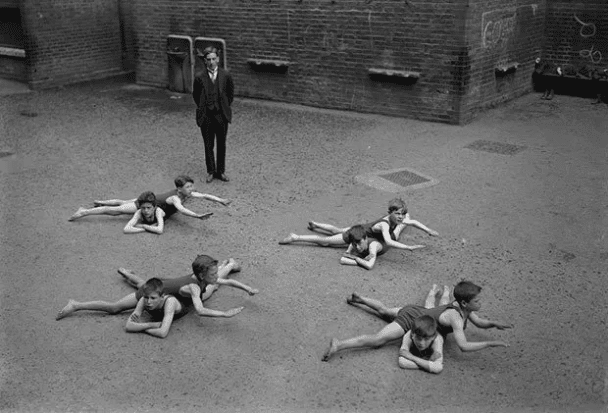 Los niños aprenden a nadar en el patio de una escuela en Inglaterra a principios de la década de 1920.