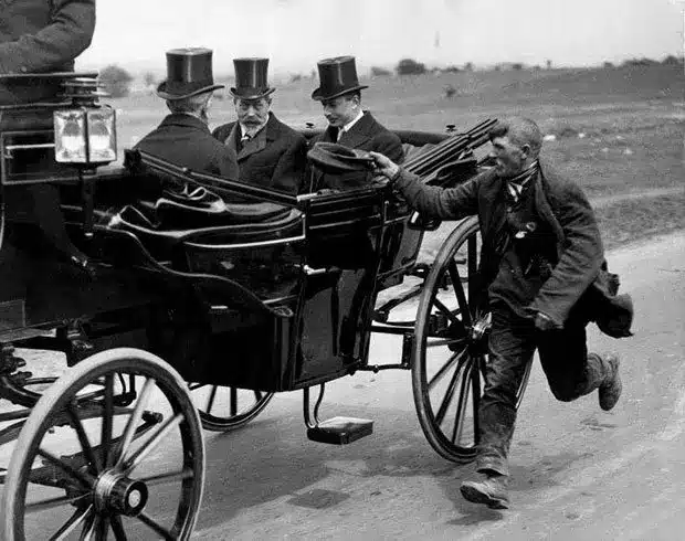 Un mendigo corriendo junto al carruaje del rey Jorge V. Inglaterra, 1920.