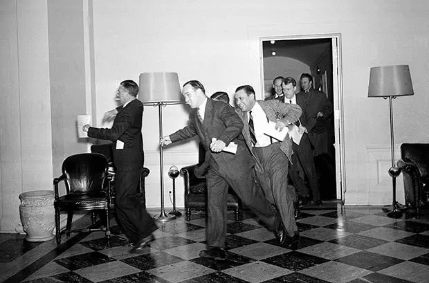 Los reporteros de la Casa Blanca se apresuran a los teléfonos después de que el secretario de prensa del presidente, Stephen T. Early, les informara que los submarinos y aviones japoneses acababan de bombardear la Flota del Pacífico de EE. UU. en Pearl Harbor, el 7 de diciembre de 1941.