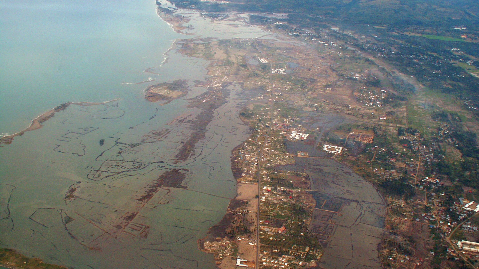 Una vista aérea de la costa devastada al sur de la ciudad de Banda Aceh, Indonesia, unos 8 meses después del terremoto y tsunami del Océano Índico de 2004. Las poderosas olas desnudaron las planicies costeras planas causando inmensas pérdidas de vidas y la devastación total de las propiedades costeras y las tierras de cultivo. (Crédito de la imagen: Fotografía de Mangiwau a través de Getty Images)