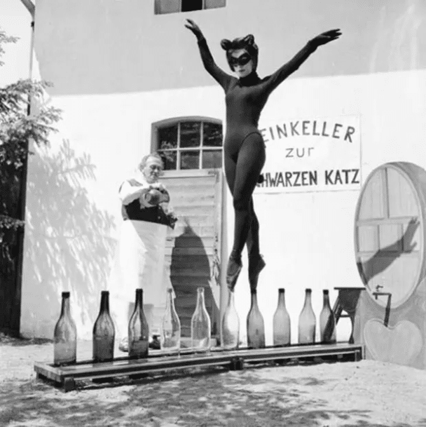 Bianca Passarge, de diecisiete años, de Hamburgo, se disfraza de gato y baila sobre botellas de vino en junio de 1958.