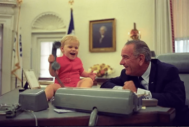 El presidente Lyndon B. Johnson observa a su nieto jugar con el teléfono - Yoichi Okamoto, 1968