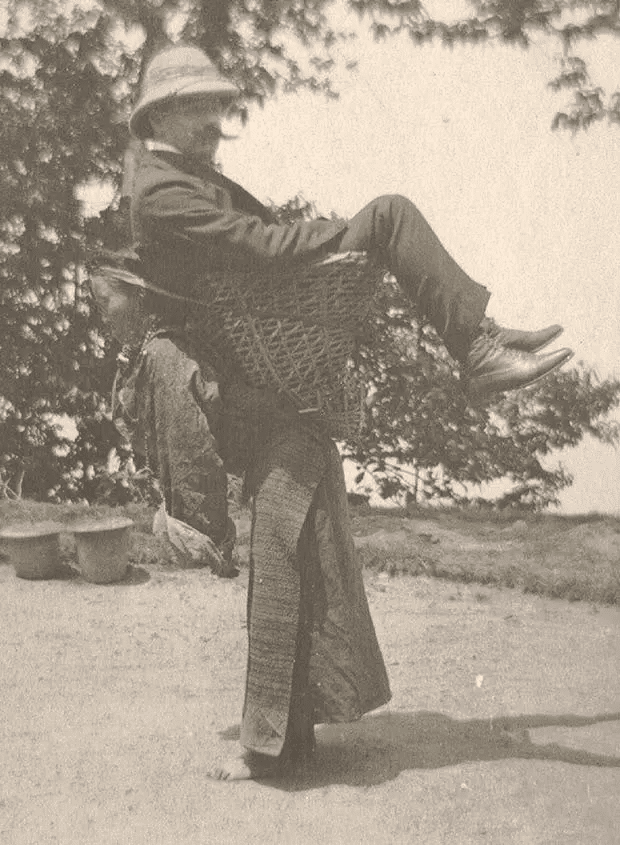 Una mujer Sikkimese llevando a un hombre británico sobre su espalda, Bengala Occidental, India. 1900.