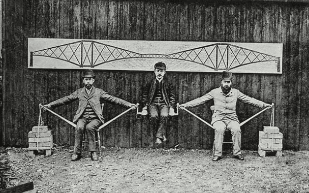 Los ingenieros de Forth Bridge demuestran los principios de la construcción en voladizo sentados en sillas de cocina. Sir John Fowler y Sir Benjamin Baker apoyan a Kaichi Watanabe sentado en una silla entre ellos con los brazos extendidos. 1887.