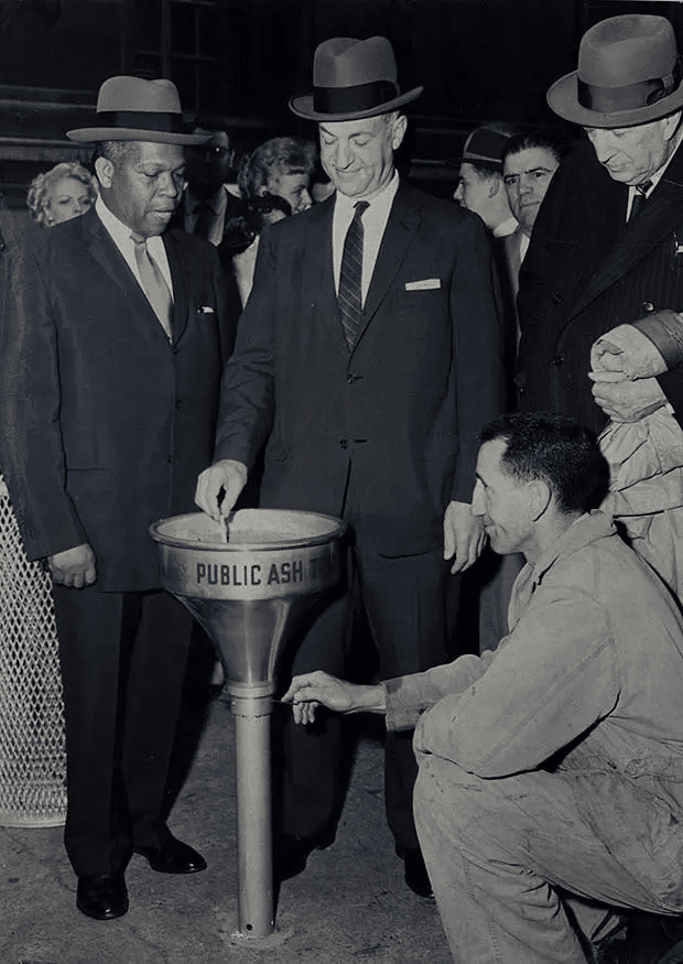 Funcionarios del gobierno celebran la instalación del primer cenicero público en las calles de la ciudad de Nueva York. (22 de abril de 1958).