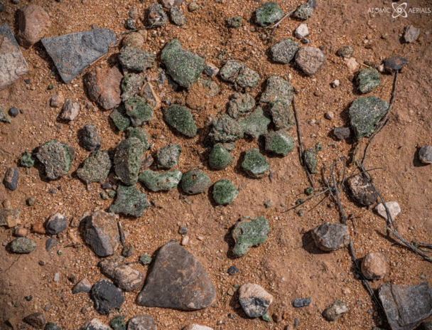 Trinitite - arena derretida en vidrio radiactivo por el calor de una bomba atómica - en todo el sitio en Trinity Site, Nuevo México