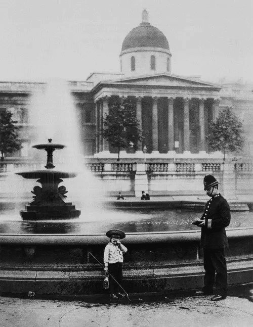 Un policía interroga a un niño que probablemente pretendía pescar en la fuente de Trafalgar Square, Londres, 1892.