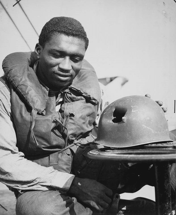 El guardacostas Charles Tyner, bombero de primera clase, inspecciona su casco golpeado por metralla durante el desembarco aliado en el sur de Francia en 1944.