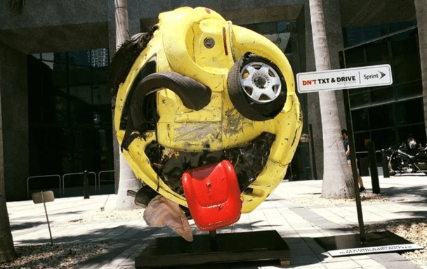 Coche destrozado convertido en un emoji para campaña antitexto y conducción