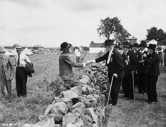Los soldados confederados y de la Unión se dan la mano a través de la pared en la reunión de 1938 de los Veteranos de la Batalla de Gettysburg.