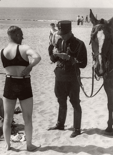 Hombre en la playa multado por no usar ropa de baño adecuada. Países Bajos, Heemskerk, 1931.